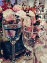 Crystal glasses with drinks on a table with flowers