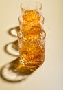 Crystal glasses of single malt whiskey with ice cubes on golden background.Hard light