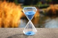 Crystal hourglass with blue sand outdoors