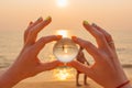 Lens ball in hand with reflection of sea and sunset on the beach Royalty Free Stock Photo