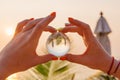 Lens ball in hand with reflection of sea and sunset on the beach Royalty Free Stock Photo