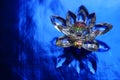 Crystal lotus on rich dark blue shiny table with light reflection. Ajna chakra or third eye symbol. Reiki meditation