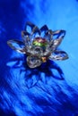 Crystal lotus on shiny dark blue table with reflection. Ajna chakra or third eye symbol