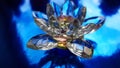 Crystal lotus on shiny dark blue table with reflection. Ajna chakra or third eye symbol