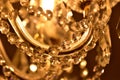 Crystal ornaments on antique chandelier. Warm white color balance. Vertical photo.