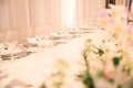CRYSTAL PLATES AND WINE GLASSES WHITE GROOM AND BRIDE WEDDING TABLE AT IMPRESSIVE COLOURFUL VENUE WITH BEAUTIFUL GREEN FLORAL DECO Royalty Free Stock Photo