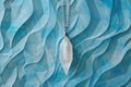 Crystal quartz pendant on swirling blue pattern background