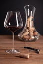 Crystal red wine glass, bottle, corkscrew, opener, sommelier knife, transparent decanter, corks on wooden table. Closeup, vertical Royalty Free Stock Photo