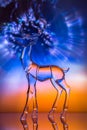 Crystal reindeer statuette in front of colorful Aurora