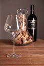 Crystal shiny glass, bottle of red wine, transparent decanter filled with corks on wooden table. Closeup, vertical, selective Royalty Free Stock Photo