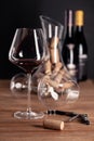 Crystal shiny glass of red wine, bottles, corkscrew, opener, sommelier knife, transparent decanter, corks on wooden table. Closeup Royalty Free Stock Photo