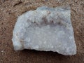 Crystal stone macro mineral surface on the sand, background wallpaper Royalty Free Stock Photo