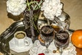 Crystal vase with carnations,black coffee,old crystal glasses with a bottle of liqueur