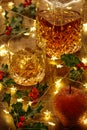 Crystal whisky decanter and a glass of whisky with ice, christmas lights and holly berrie Royalty Free Stock Photo