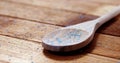 Crystals of blue frit glass falling wooden spoon