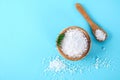 Crystals of large sea salt in a wooden bowl and spoon and dill on a blue table. Royalty Free Stock Photo