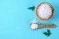 Crystals of large sea salt in a wooden bowl and spoon and dill on a blue table. Background for advertising salt. Table salty. Salt Royalty Free Stock Photo