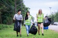 CSR activity. Corporate Social Responsibility. Three volunteers, Asian male, female and Caucasian are helping to pick up waste by