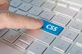 CSS computer language. writing on button modern of gray laptop. Finger presses the button. Programmer for work. Royalty Free Stock Photo
