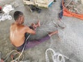 Ctivity of fisherman knitting or repairing their fishing net at the harbor dock