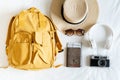 CTravel accessories with beach hat, sunglasses, backpack, camera, headphone and passport on bed at home. Prepare to travel,