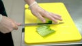 CU: Cook cleverly cuts the skin of the fresh cucumber with a knife.