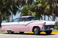 Cuba american white Oldtimer parked under palms