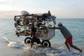 Cuba: Beach souvenier trader at Varadero beach pushing his heavy
