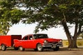 Cuba, Havana - January 16, 2019: Old American red car in the old city of Havana against the tropical tree Royalty Free Stock Photo