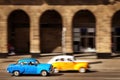 Cuba, Havana - January 16, 2019: Old yellow and blue cars in the old city of Havana against the backdrop of Spanish colonial archi