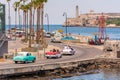 CUBA, HAVANA - MAY 5, 2017: American colorful retro cars traveling along the waterfront. Copy space for text.