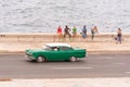 CUBA, HAVANA - MAY 5, 2017: American green retro car rides along the waterfront. Copy space for text.