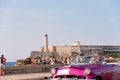 CUBA, HAVANA - MAY 5, 2017: American pink retro-cabriolet on the lighthouse background. Copy space for text.