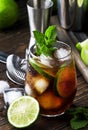 Cuba libre alcohol cocktail with golden rum, lemon juice, cola, lime and ice, dark bar counter background, bar tools, place for Royalty Free Stock Photo