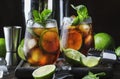 Cuba libre alcohol cocktail with golden rum, lemon juice, cola, lime and ice, dark bar counter background, bar tools, place for Royalty Free Stock Photo