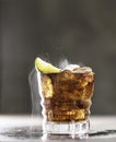 Cuba Libre with brown rum, cola, mint and lime. Cold Longdrink, alcohol cocktail. Place for text Royalty Free Stock Photo