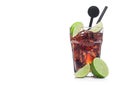Cuba Libre Cocktail in glass with ice cubes and slices of lime with black straw and stirrer on white with raw limes Royalty Free Stock Photo