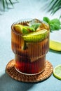 Cuba Libre with rum, cola, mint and lime in the glass on a light background, vertical image. top view. place for text Royalty Free Stock Photo