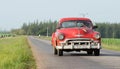 Cuba red american classic car drives on the street in the province