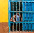 CUBA, TRINIDAD. June 2016: Two children looking out of the window of their house in Trinidad. Royalty Free Stock Photo