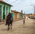 Cuban cowboy riding a horse on cobblestone street wearing sombrero in Trinidad, Cuba Royalty Free Stock Photo