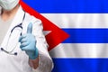 Cuban doctor's hand showing thumb up positive gesture on flag of Cuba background