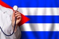 Cuban doctor's hand with stethoscope on the background of flag of Cuba Medicine, clinic, practitioner, healthcare