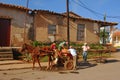 Cuban farmers moving farm harvest from horse cart to mobile stall cart