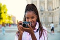 Cuban female tourist taking photos with a camera sightseeing in Madrid, Spain.