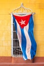 Cuban flag hanging at the window of a colorful house in a street of Trinidad Cuba Royalty Free Stock Photo