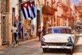 Cuban flags,old car and  decaying buildings in Havana Royalty Free Stock Photo