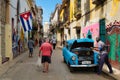 Cuban flags, old car and decaying buildings in Old Havana Royalty Free Stock Photo