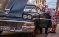 Cuban mechanic fixing oldtimer after breakdown