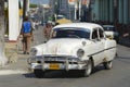 Cuban person drives vintage American car at the street of Pinar del Rio, Cuba.